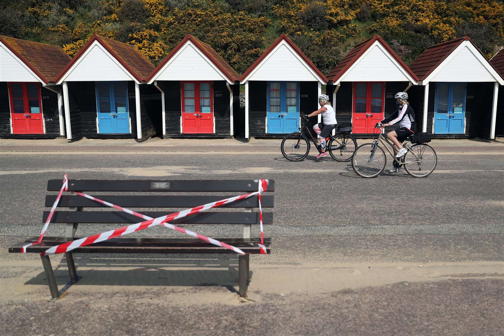 Cyclists making their way past a taped-off bench on the seafront at Bournemouth (Andrew Matthews/PA)