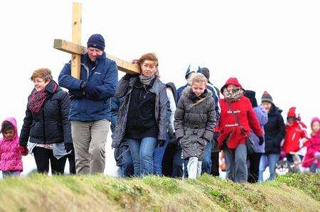 Steve Brown, helped by Tracey Wynn, carries a cross with other members of St Henry and St Elizabeth Roman Catholic Church in Broadway, Sheerness