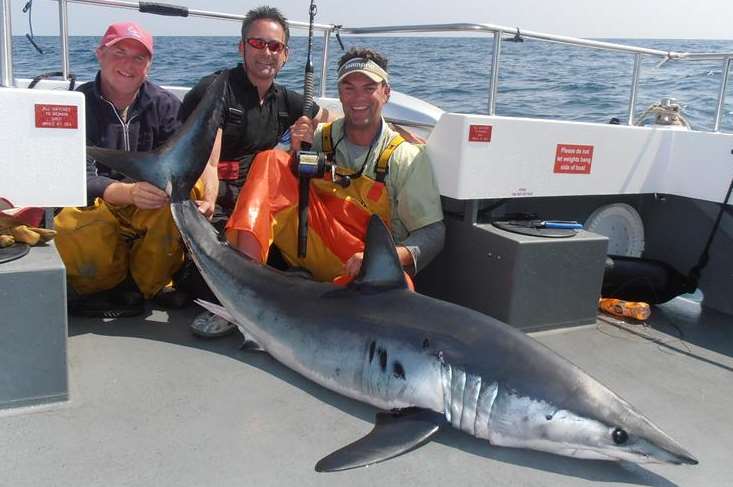 Angler Andrew Griffith (centre) with a 194lb pound shark
