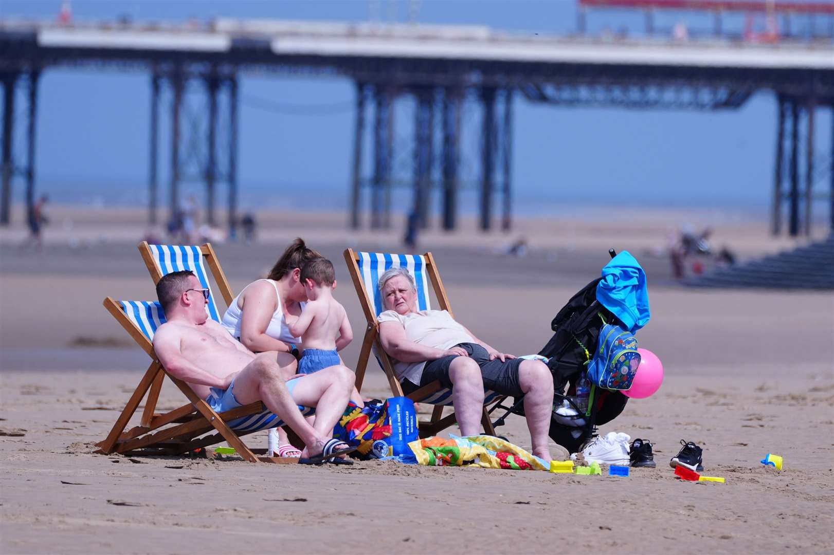 People enjoy warm weather on Blackpool beach in Lancashire at the end of June (Peter Byrne/PA)