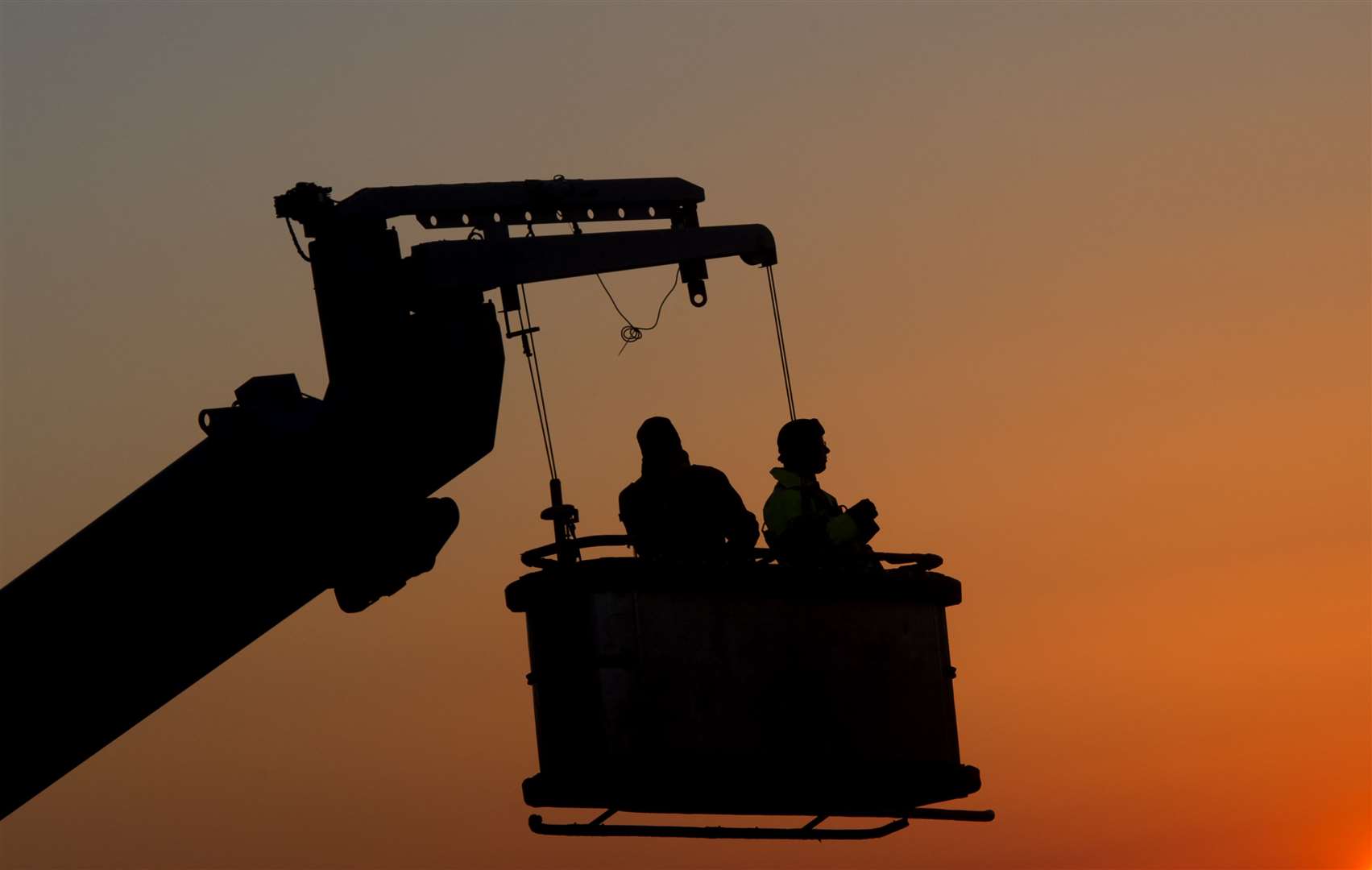 Construction workers watch the sun set (Hannah McKay/PA)