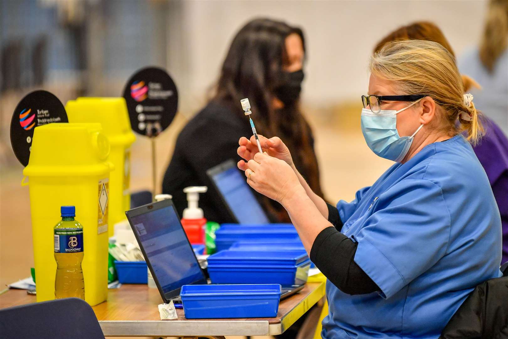 Healthcare workers giving out injections of the Pfizer vaccine at a coronavirus vaccination centre (Ben Birchall/PA)