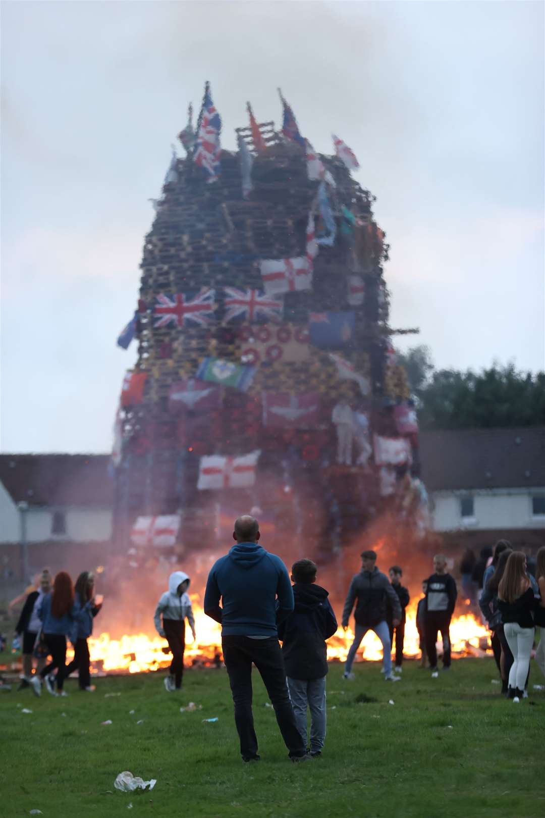 Flags and banners hang from a large bonfire in the Galliagh area of Londonderry (Liam McBurney/PA)