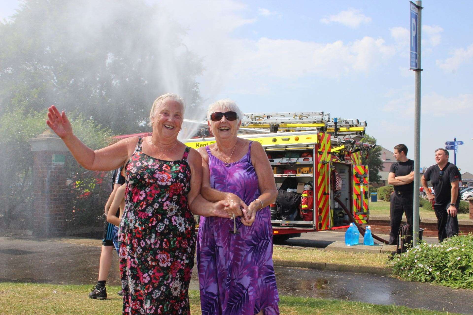 Water grannies: Sisters Margaret Firth, left, and Val Johnson, both in their 70s, cool down in a water mist provided by Kent Fire and Rescue Services at Beachfields Park, Sheerness, on the Isle of Sheppey. Picture: John Nurden (14293466)