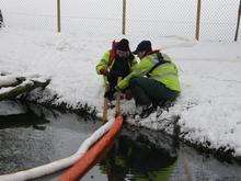 Environment Agency staff working in the snow to stop oil spilling into Maidstone water courses