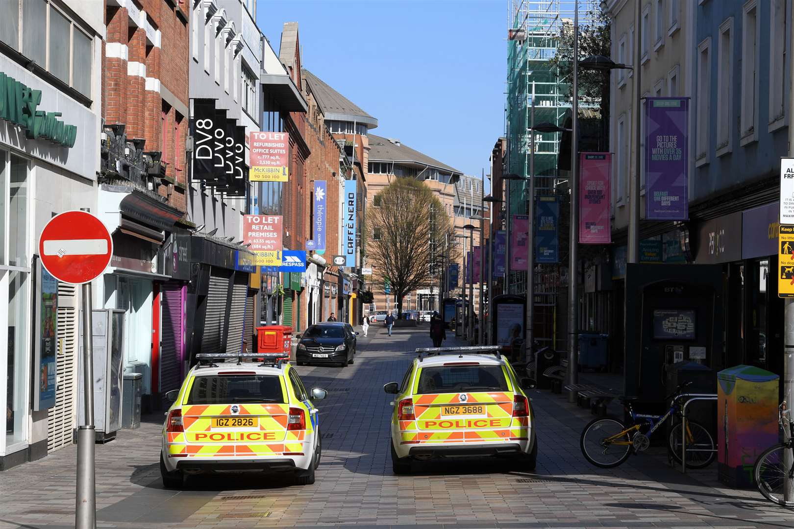 Shuttered stores and police patrols on Ann Street in Belfast (Justin Kernoghan/PA)