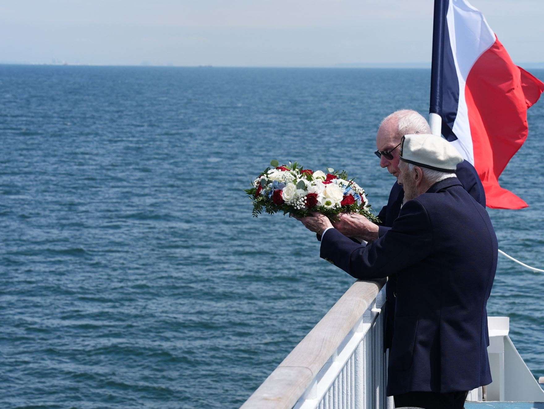 D-Day veterans Harry Birdsall, 98, and Alec Penstone (front), 98, throw a wreath into the sea (Jordan Pettitt/PA)