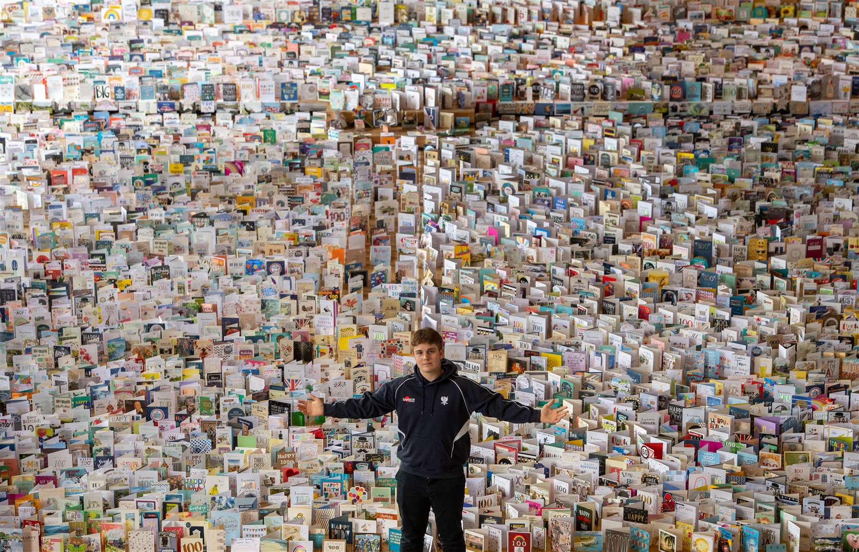 Grandson Benjie in the Great Hall of Bedford School with the thousands of birthday cards sent to mark Captain Sir Tom Moore’s 100th birthday in April (Joe Giddens/PA)