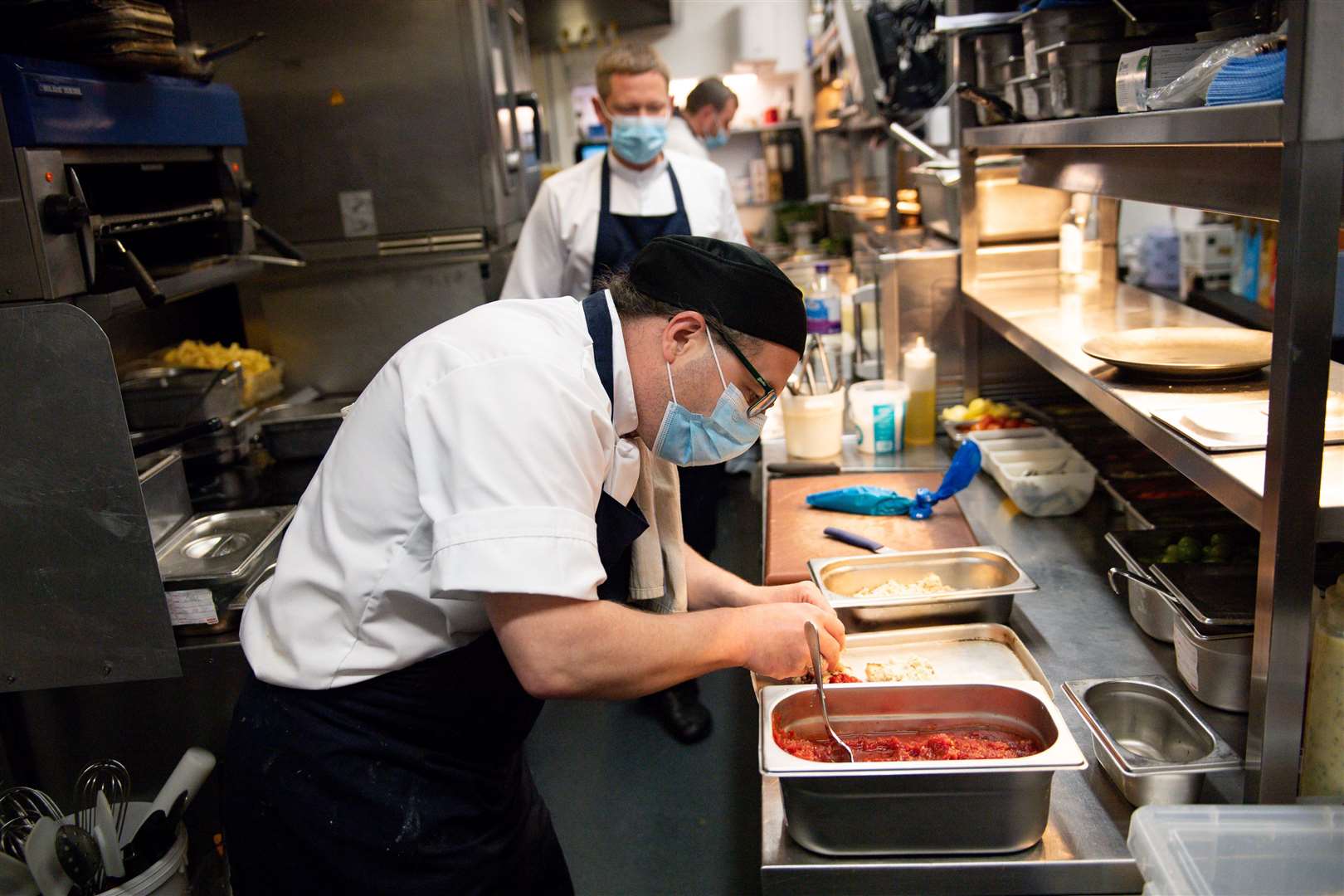 Staff members wear masks as they work in the kitchen at Loxleys Restaurant & Wine Bar in Stratford, Warwickshire (Jacob King/PA)