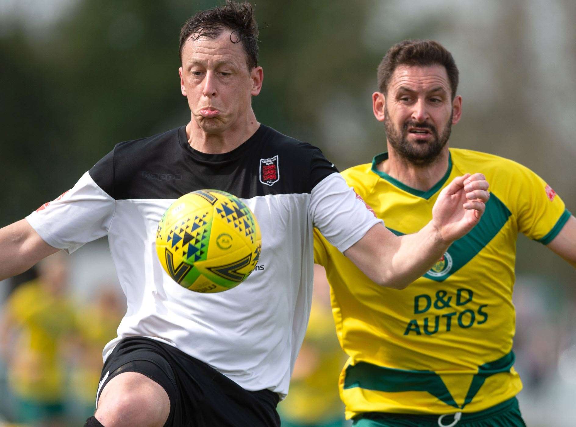 Faversham defender Matt Bourne beats Ashford's Jay May to the ball in a 3-1 home win for the Lilywhites on Monday. Picture: Ian Scammell