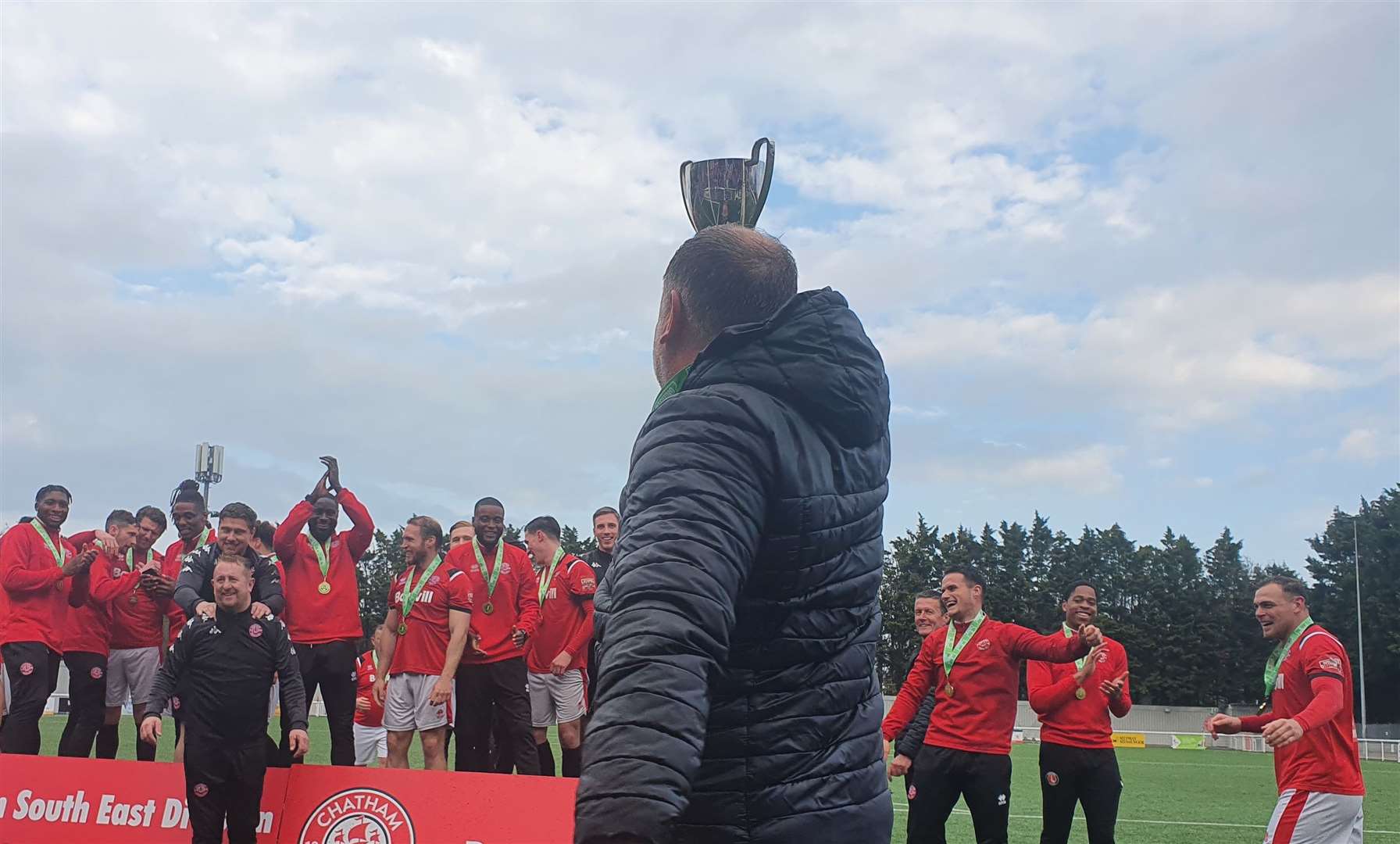 Chatham boss Kevin Hake holds the trophy aloft