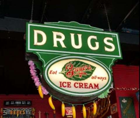 An American drug store sign hangs from the ceiling