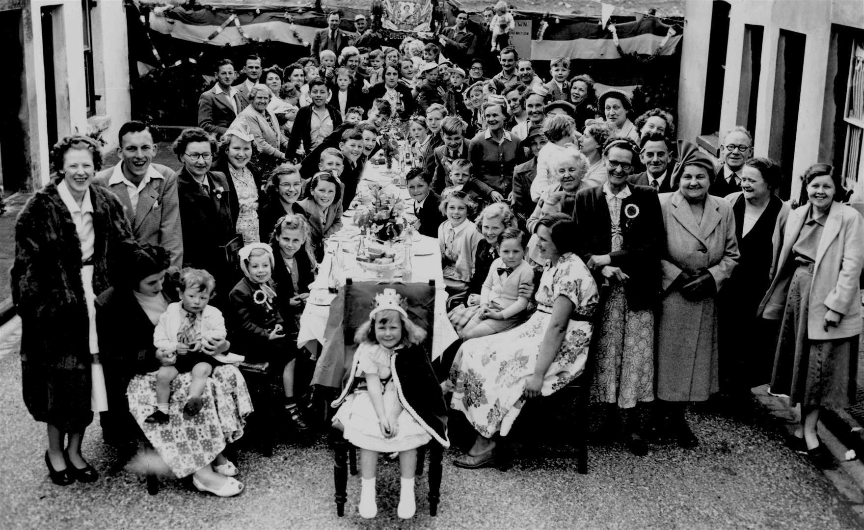 A little girl in royal robes takes to the head of the table in New Town Street, Canterbury