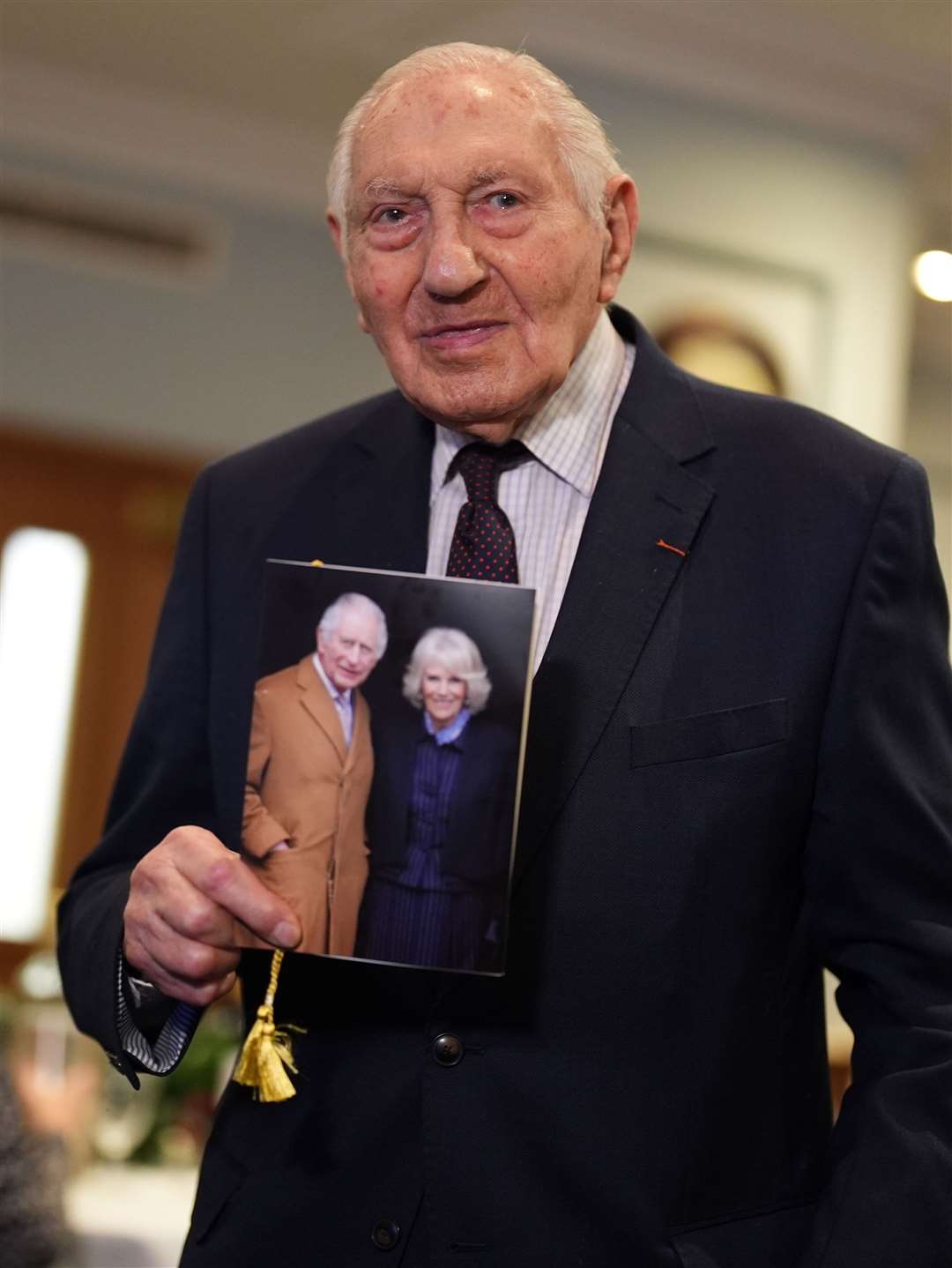 Normandy veteran Mervyn Kersh holds his card from the King and Queen during a surprise party for his 100th birthday (Jordan Pettitt/PA)