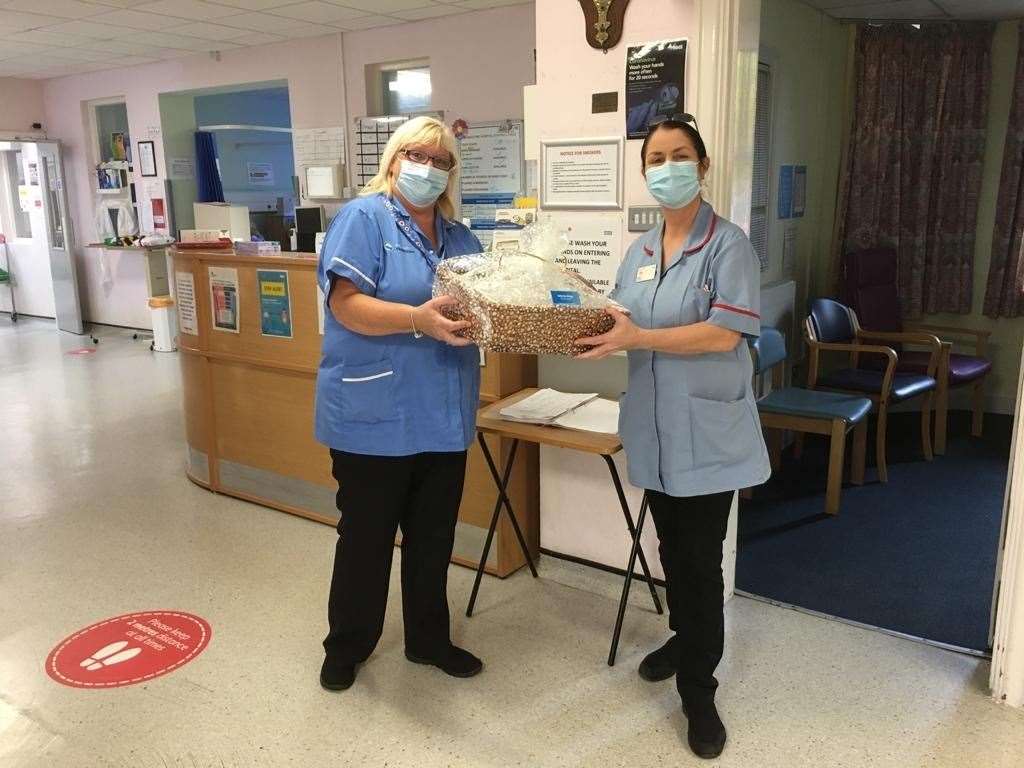 From left: Tracey Quirk, activities coordinator at Haslington Lodge Care Home, presents the home-made gift to Tracey Dangolitis at Livingstone Community Hospital in Dartford