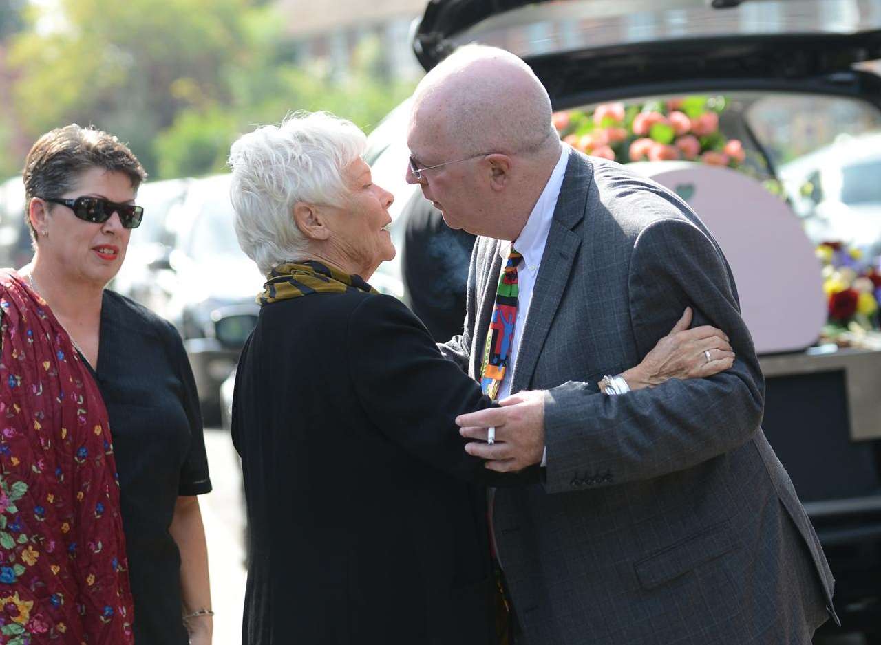 Dame Judi Dench is greeted by family members