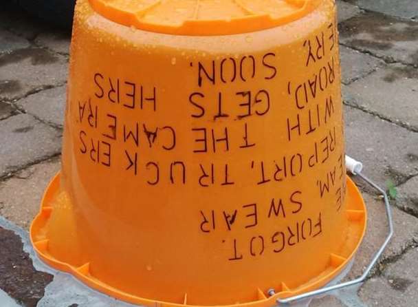 The orange bucket found near the pensioner's car which contained the paint and the written threat on its side