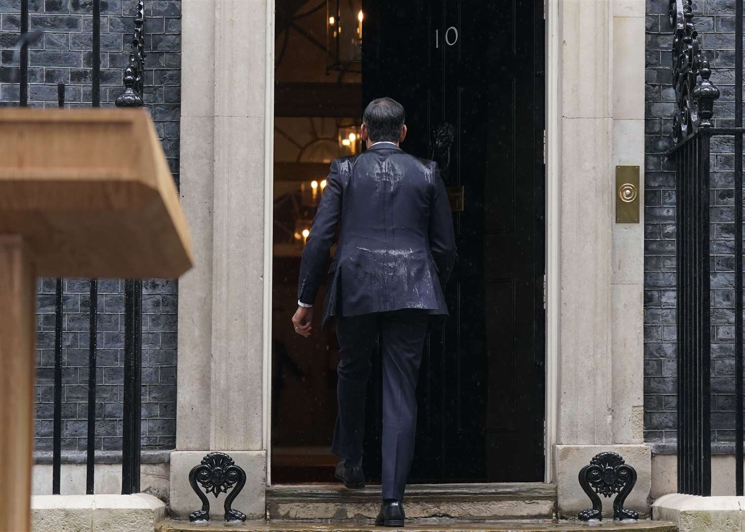 Prime Minister Rishi Sunak, soaked by rain, walks back in to 10 Downing Street after issuing a statement calling a General Election for July 4 (Stefan Rousseau/PA)