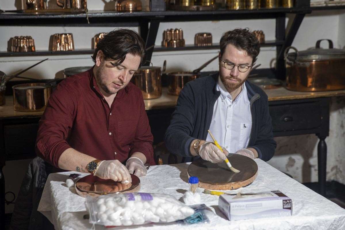 Neil Watt and Kris Reid polishing Castle Ward’s vast collection of culinary tools (Liam McBurney/PA)