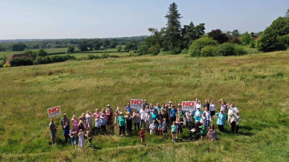 Protesters stand in the fields where homes could be built (13225731)