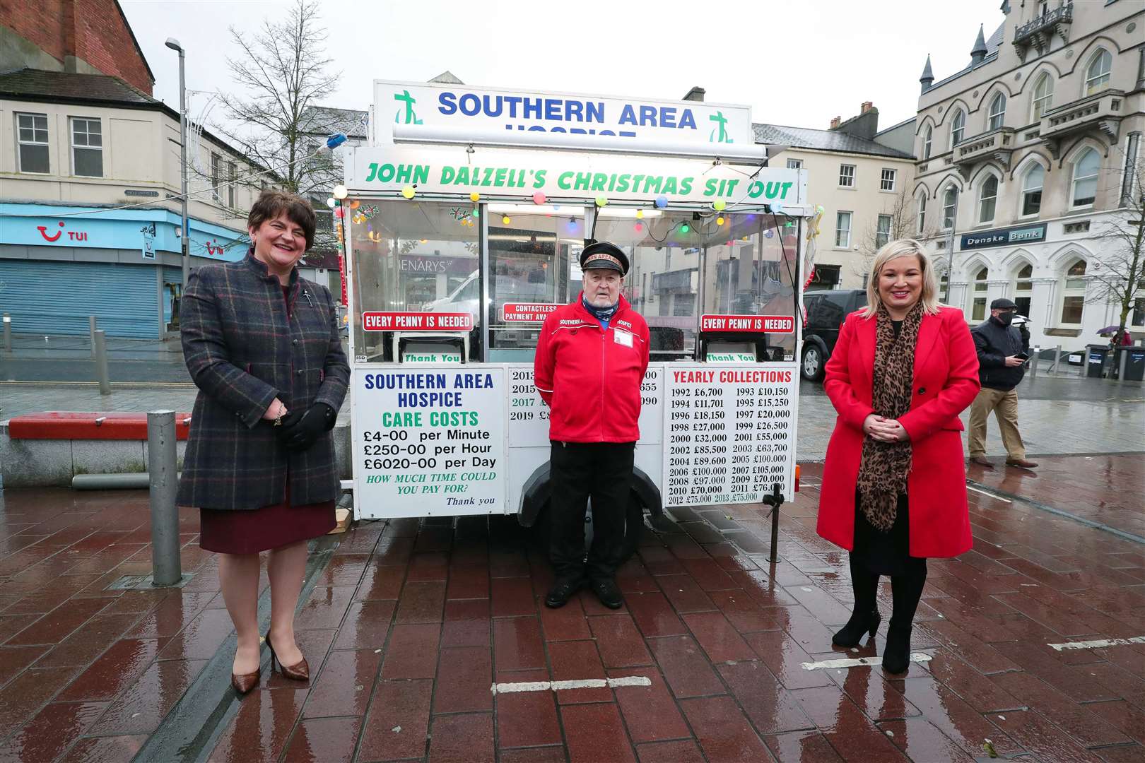 Arlene Foster and Michelle O’Neill, right, visit Newry to meet John Dalzell, who stages a sit-out every Christmas to raise money for the Southern Area Hospice (Presseye/PA)