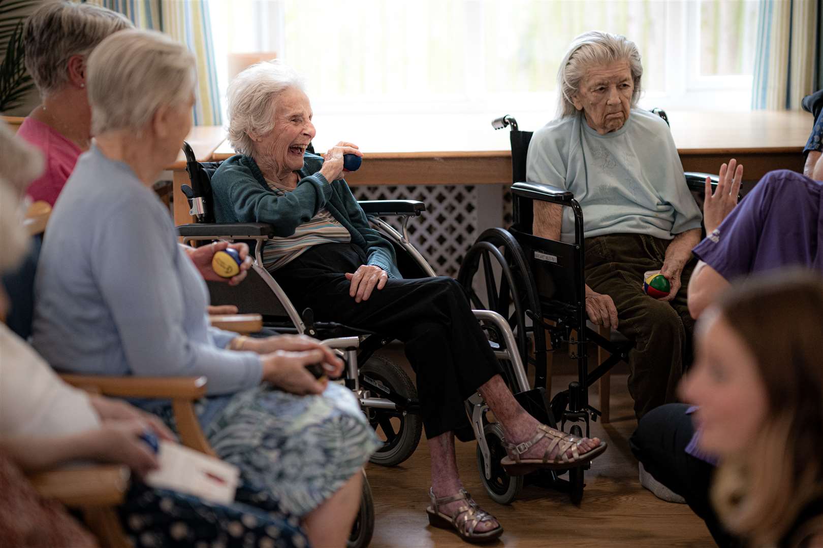 Mary Griffin, 93, centre left, laughs as she plays with a juggling ball (Ben Birchall/PA)