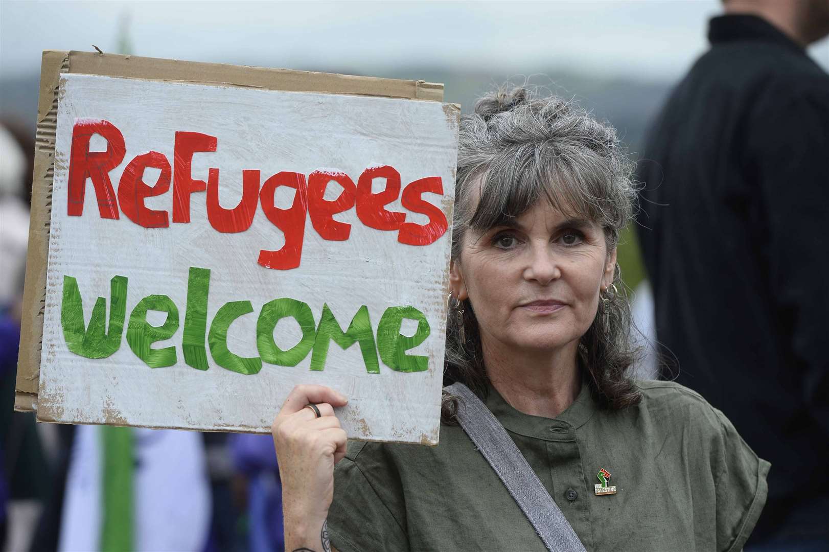 A woman holds up a sign during a protest by unions at Stormont (Mark Marlow/PA)