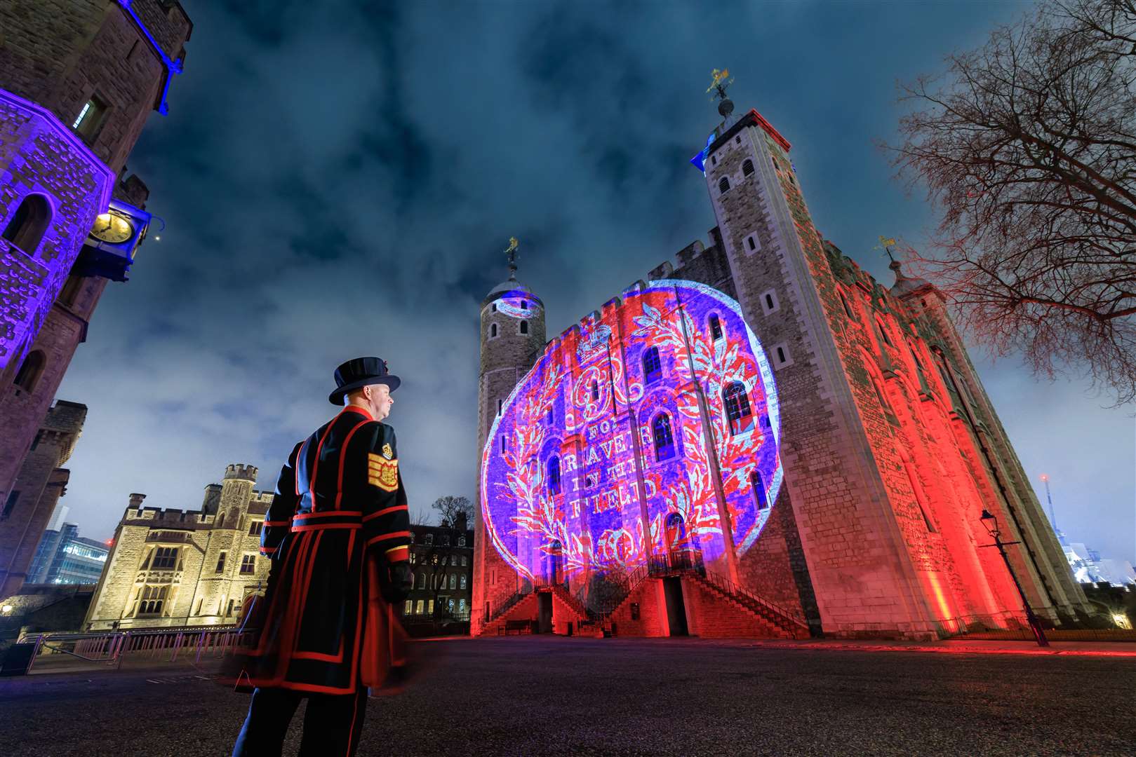 Yeoman Gaoler Clive Towell looks at the image of the World War One military medal for bravery in the field (Luxmuralis/Historic Royal Palaces/PA)