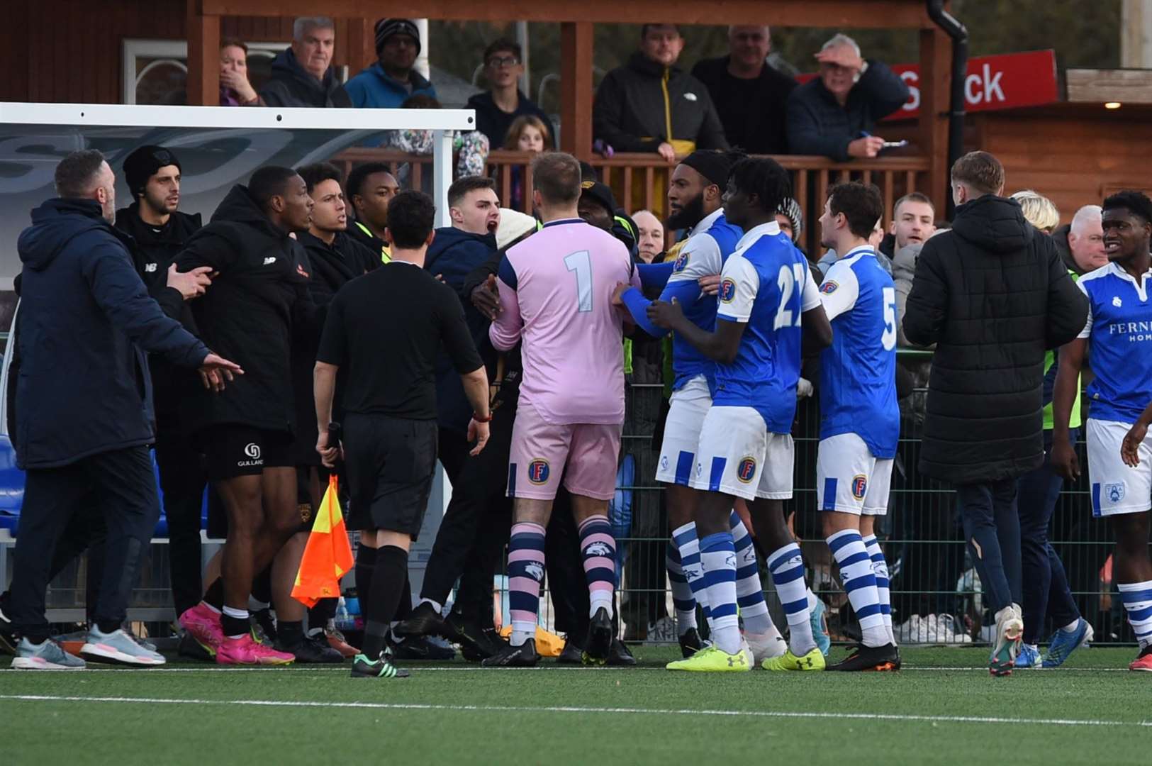 Raphe Brown, behind the linesman, watches on as the fracas plays out. Picture: Steve Terrell