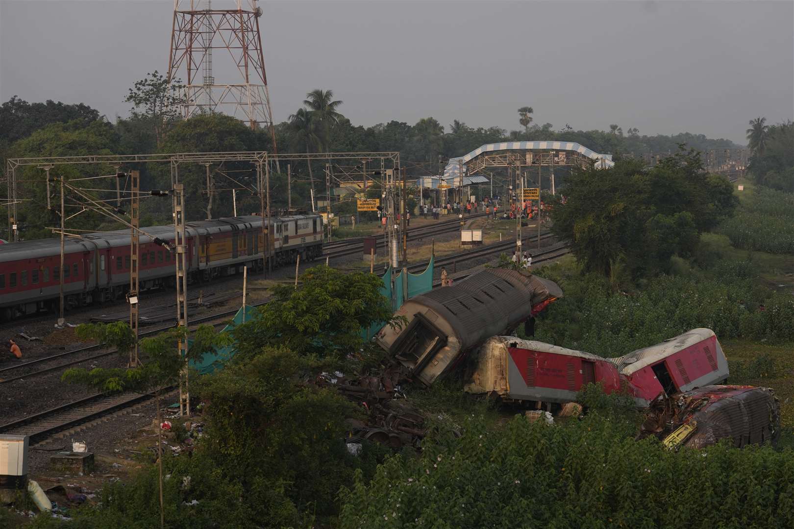 A passenger train passes the site where the trains derailed (Rafiq Maqbool/AP)