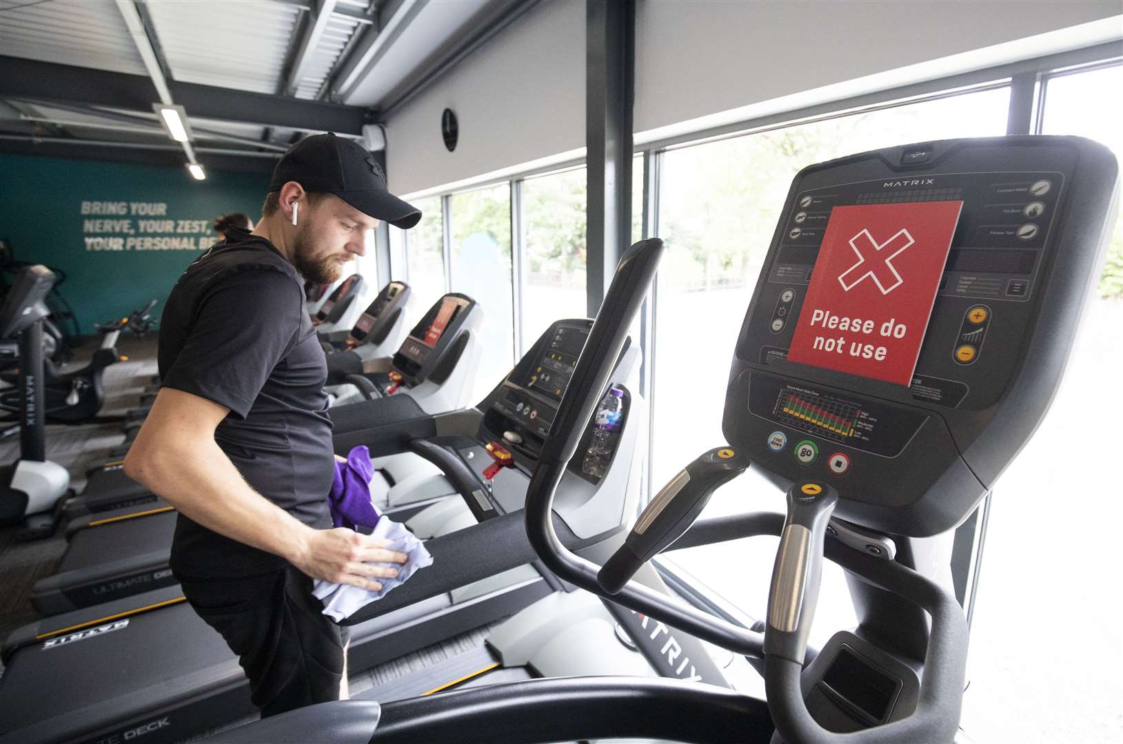 Gym members clean fitness equipment after a workout at a PureGym Local in Kirkcaldy, Fife.