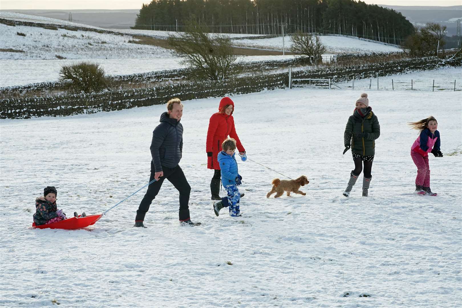 A family takes advantage of the Christmas Day snow with a trip out sledging on the hills near Hexham, Northumberland (PA)