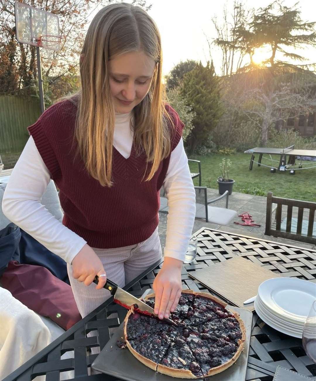 Anya serving up a fruit tart for her family at home