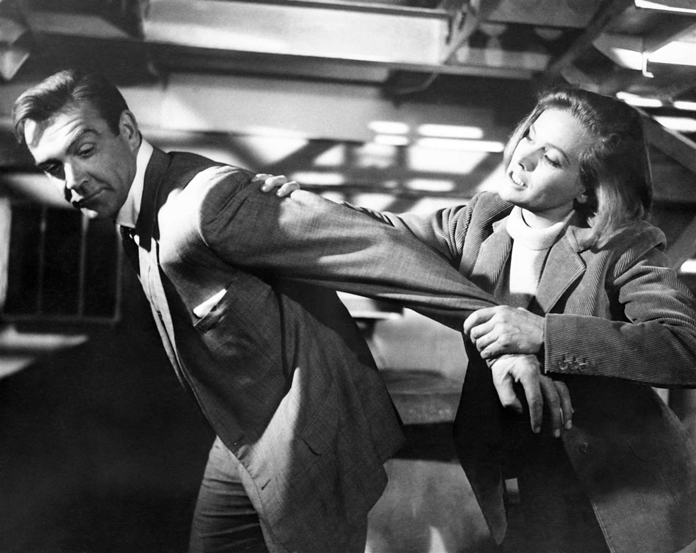 Blackman puts Sean Connery in an arm lock during a scene for Goldfinger (PA Archive)