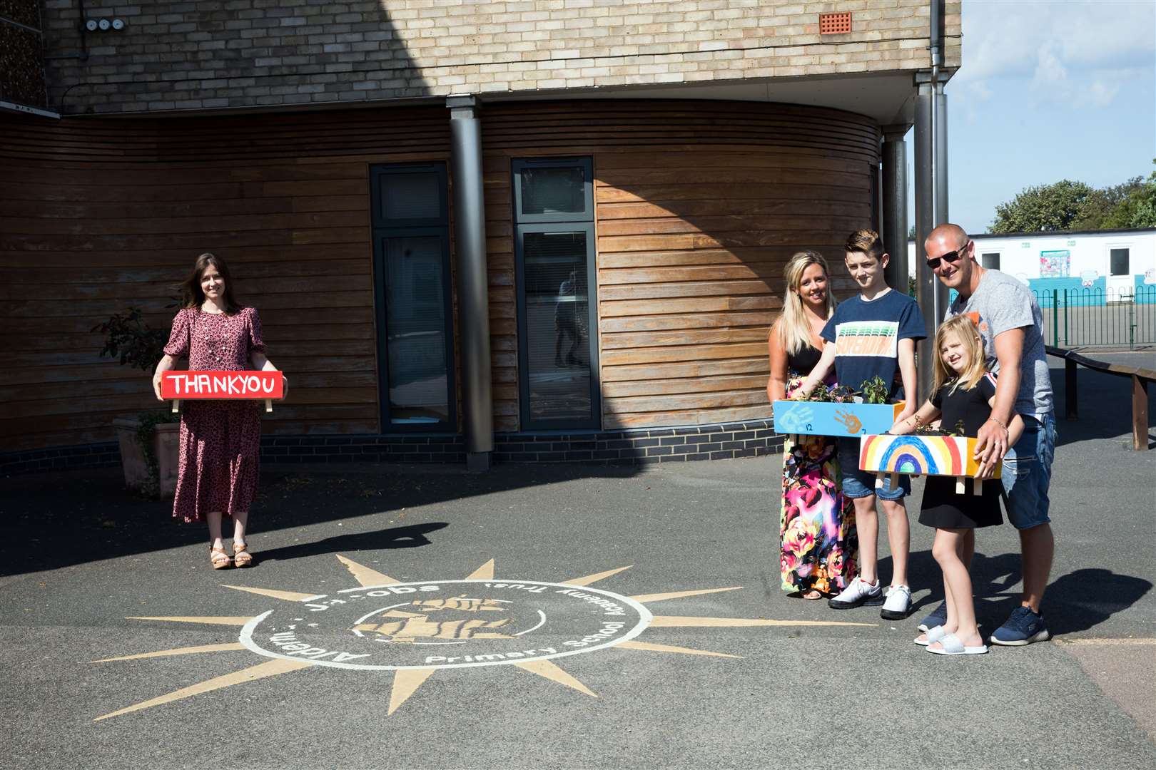 The Peart family hand over some of planters to Elaine Crane, deputy headteacher of Alderman Jacobs Primary School in Whittlesey (National Lottery/PA)