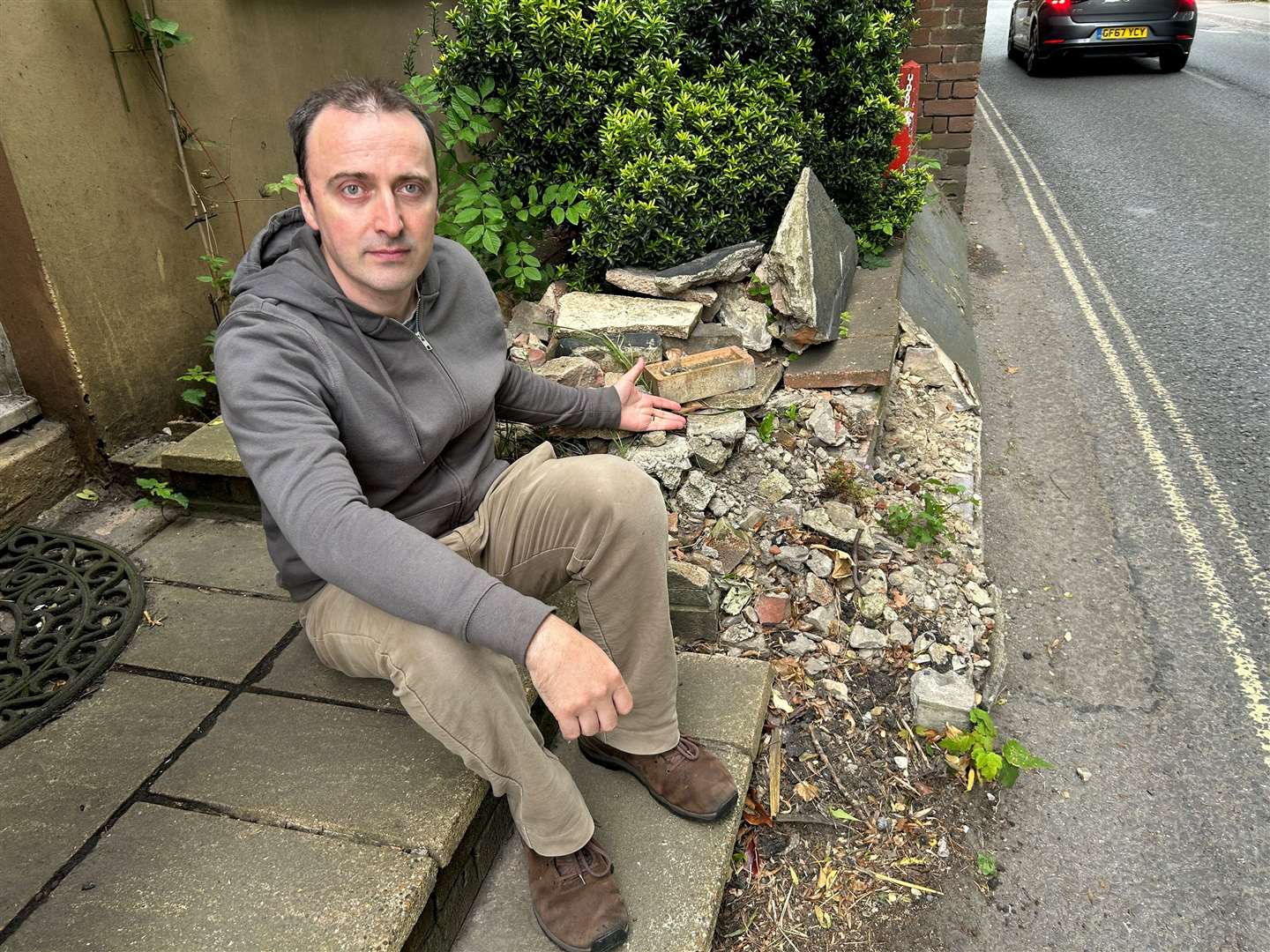 Dr Tom Nichols with his neighbour’s wall, which was destroyed by a car