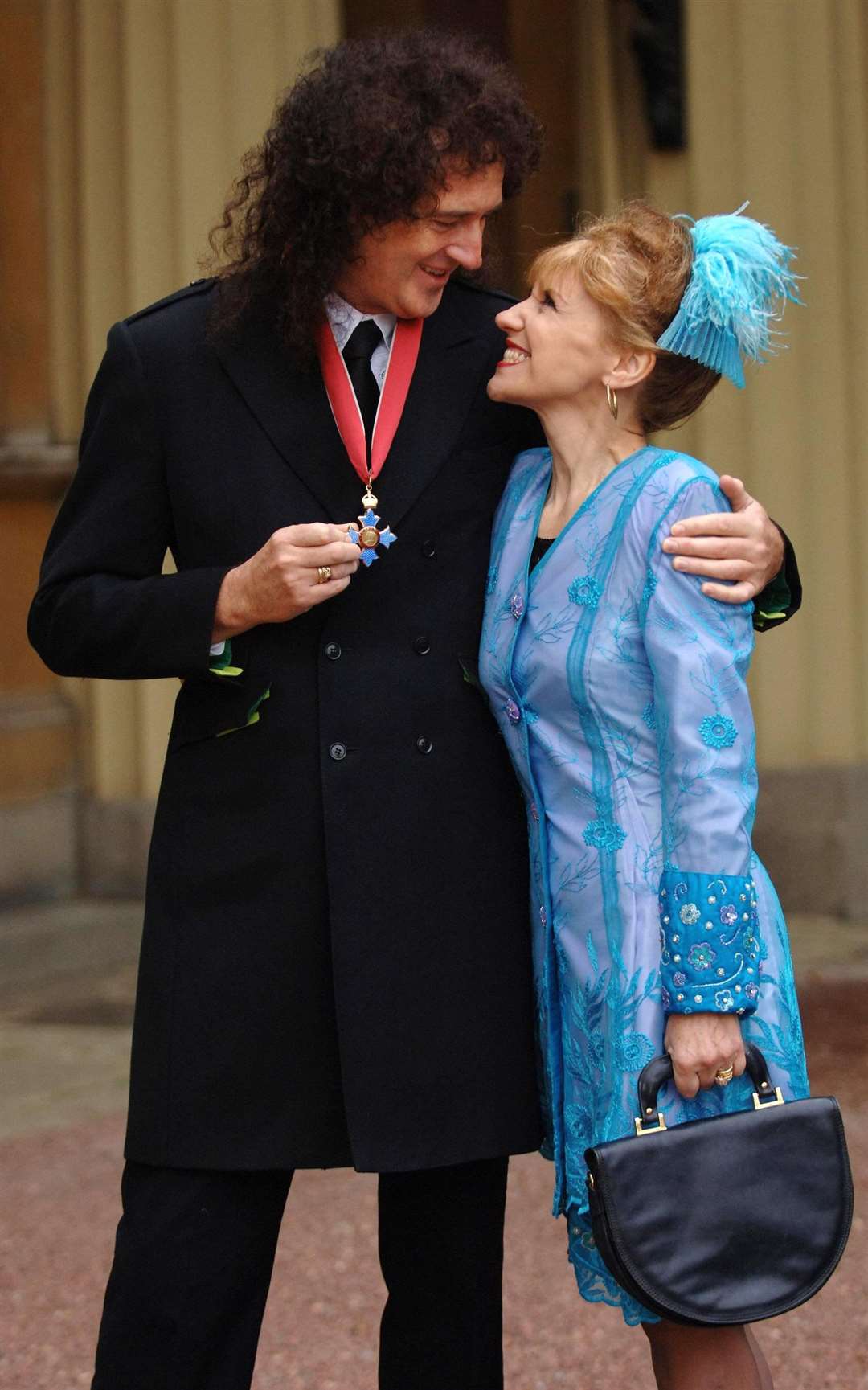 Brian May and his actress wife Anita Dobson after the guitarist collected his CBE from the late Queen in 2005 (Fiona Hanson/WPA Rota/PA)