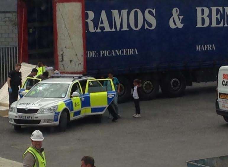 A child stands by the police car