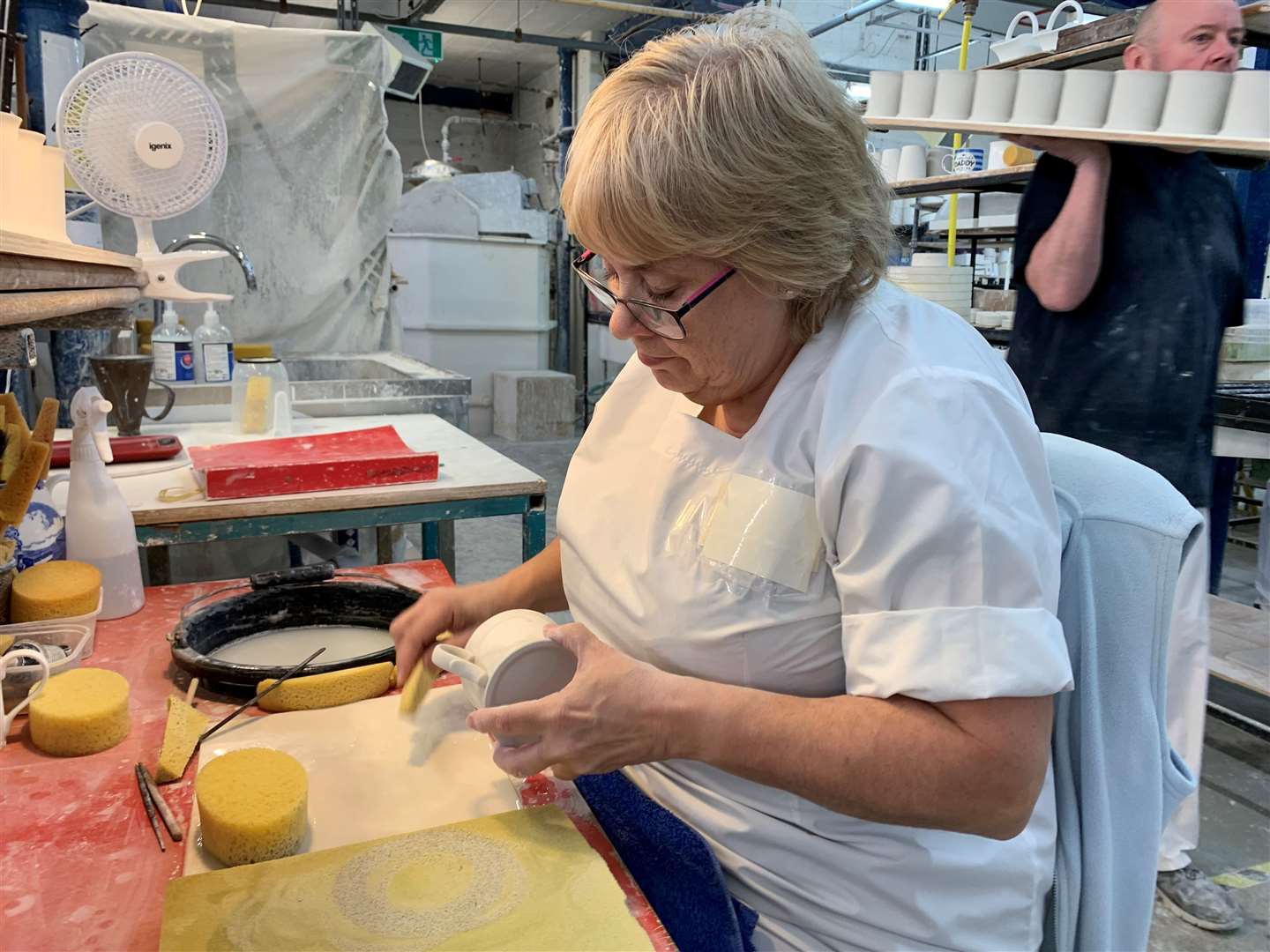 Hand-finishing the unfired clay pieces involves processes like sponging and also fettling to remove the mould seams (Richard Vernalls/PA)