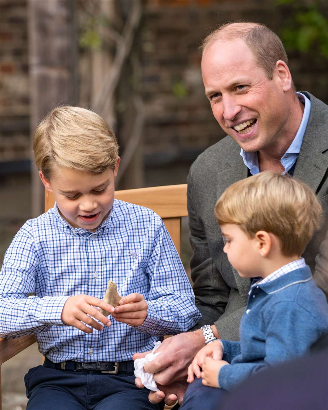 The Duke of Cambridge and Prince Louis watch as Prince George holds the tooth of a giant shark (Kensington Palace/PA)