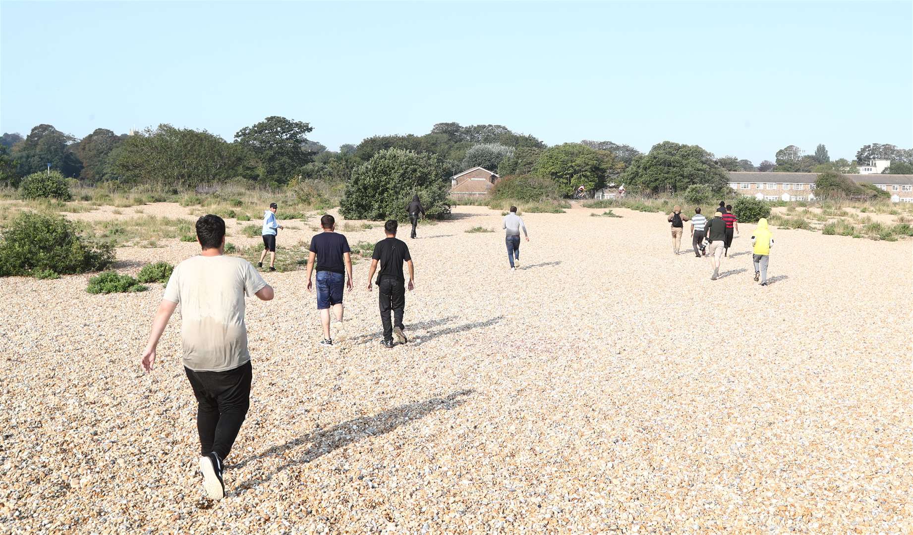 The dinghy passengers run across the beach after landing at Kingsdown in Kent (Gareth Fuller/PA)