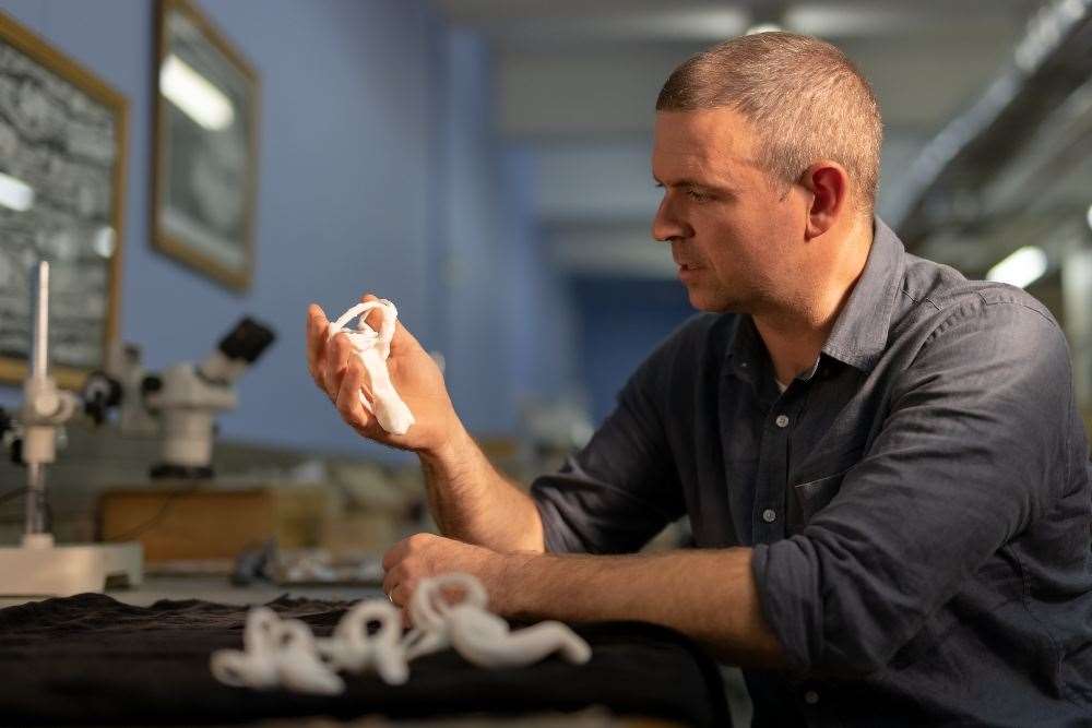 Professor Jonah Choiniere with a 3D printed model of the Shuvuuia lagena (Jonah Choiniere/Wits University/PA)