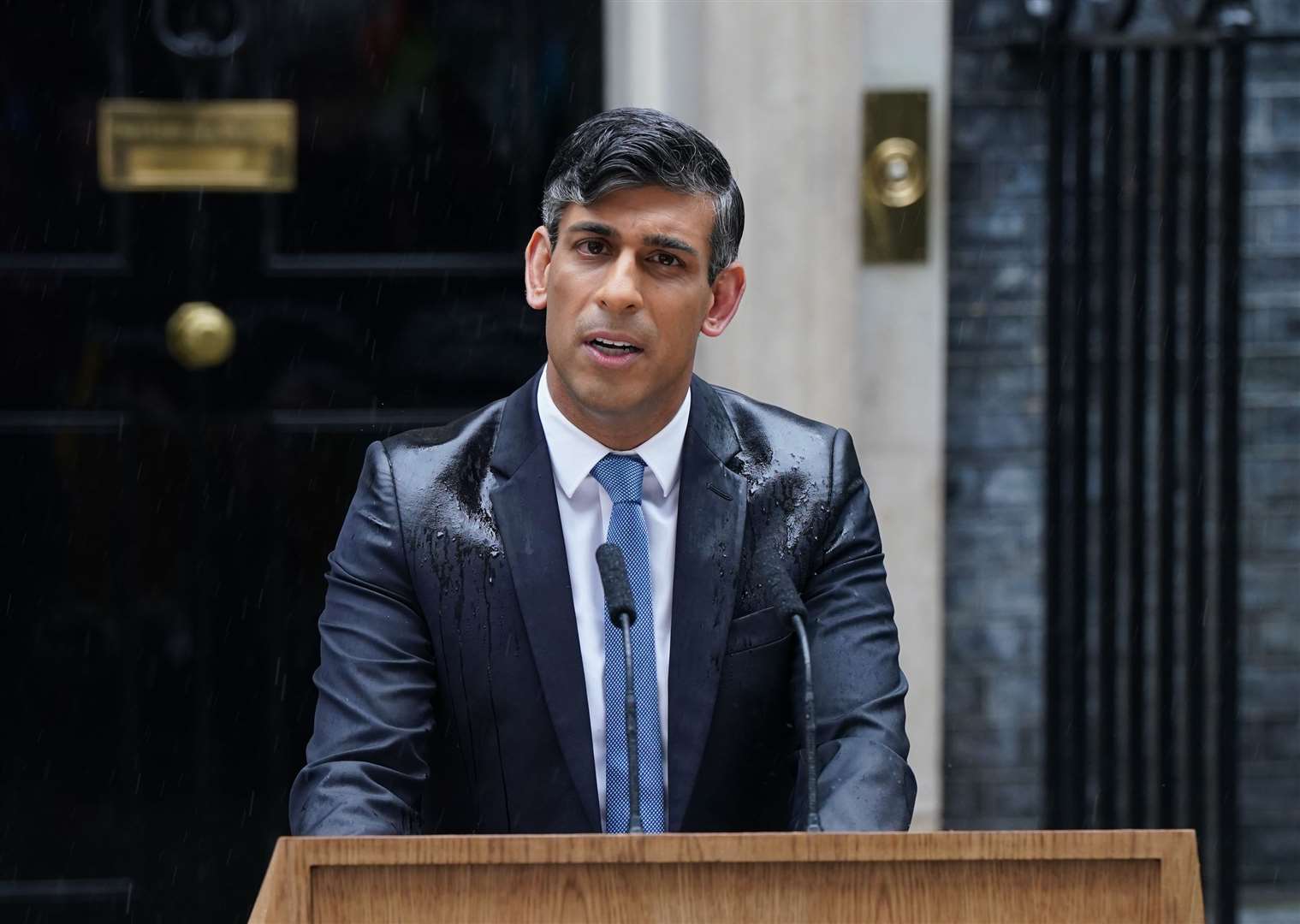 A rain-drenched Rishi Sunak announces his decision to call a general election (Lucy North/PA)