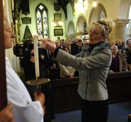 Cllr Jan Tranter lights a candle in memory of the tragedy. Picture: MATT McARDLE