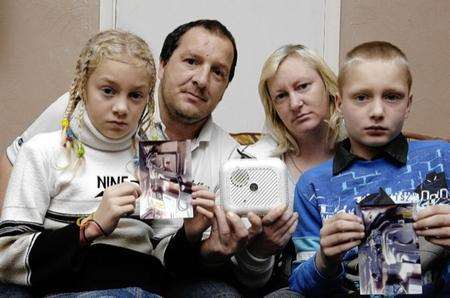 L-R Chloe, Ryan, Karen and Cameron Bennett with the melted fuse-box and the life-saving smoke alarm