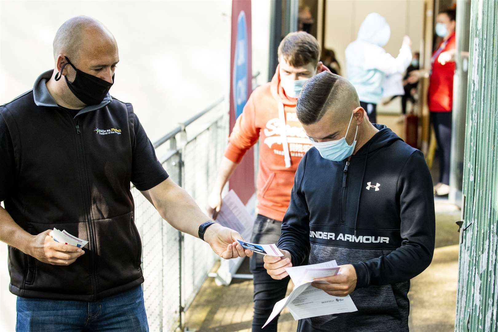 Feile an Phobail organiser Kevin Gamble (left) giving Peter Berne (right) a ticket to the festival’s music night after he received his first vaccination at the Falls Park Bowling Pavilion in Belfast (Liam McBurney/PA)