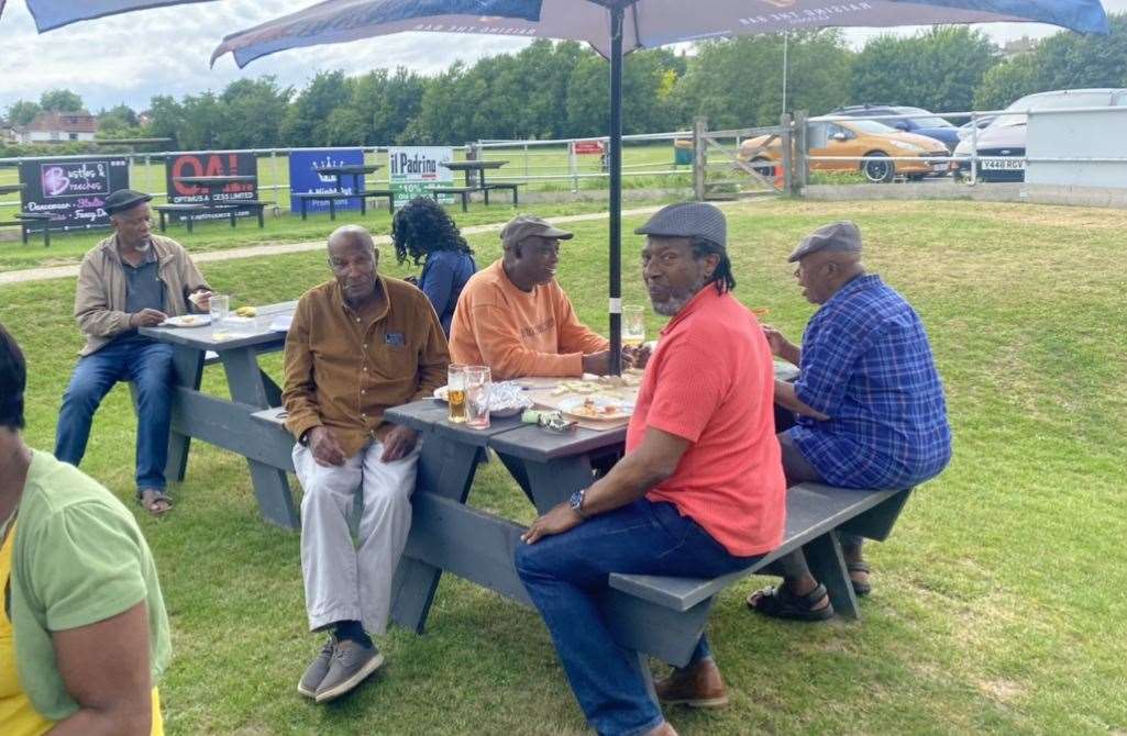 Men and women enjoying lunch and playing dominos