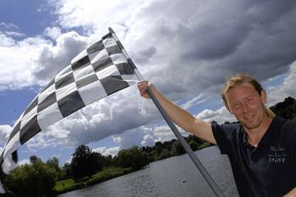 Stuart Clarke of Mote Park Watersports Centre waves on the KM Dragon Boat Race at Mote Park, Maidstone