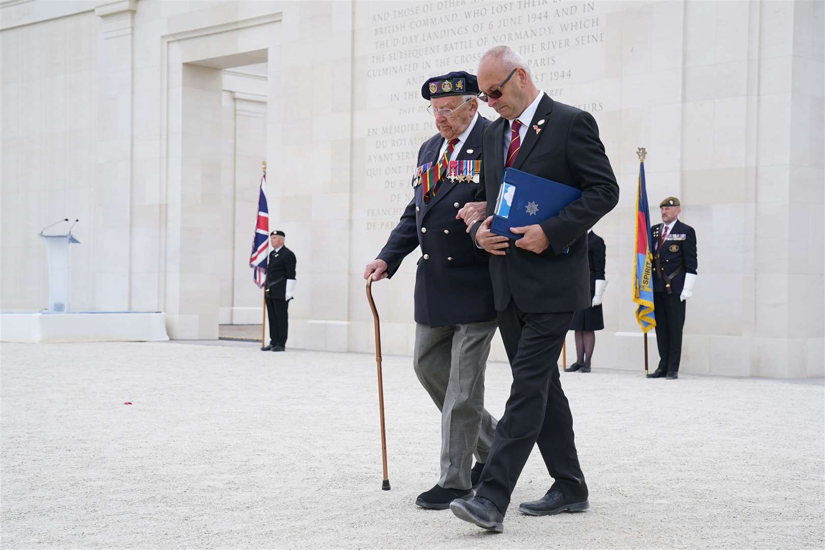 D-Day veteran Ken Hay (left) is guided back to his seat after speaking at the service (Gareth Fuller/PA)