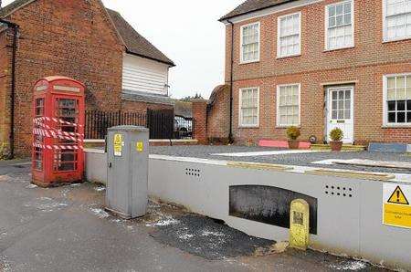 Red phonebox, Upper Bridge Street, Wye. The phonebox has been moved to allow access to ancient wine cellar.